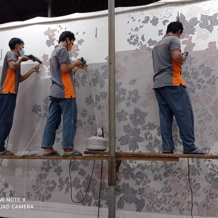 Pengrajin hand-tufting karpet motif bunga kustom di atas bingkai di studio