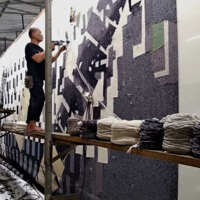 Pengrajin membuat karpet motif Industrial berukuran besar secara hand-tufting menggunakan senapan tufting